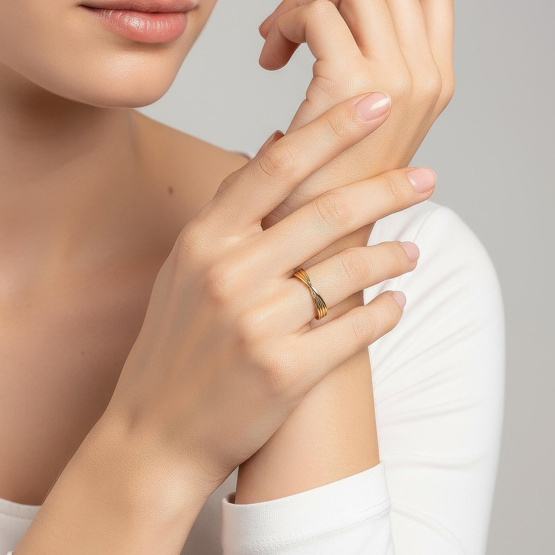 14K yellow gold crossover multi-line ring styled on hand with polished intersecting bands