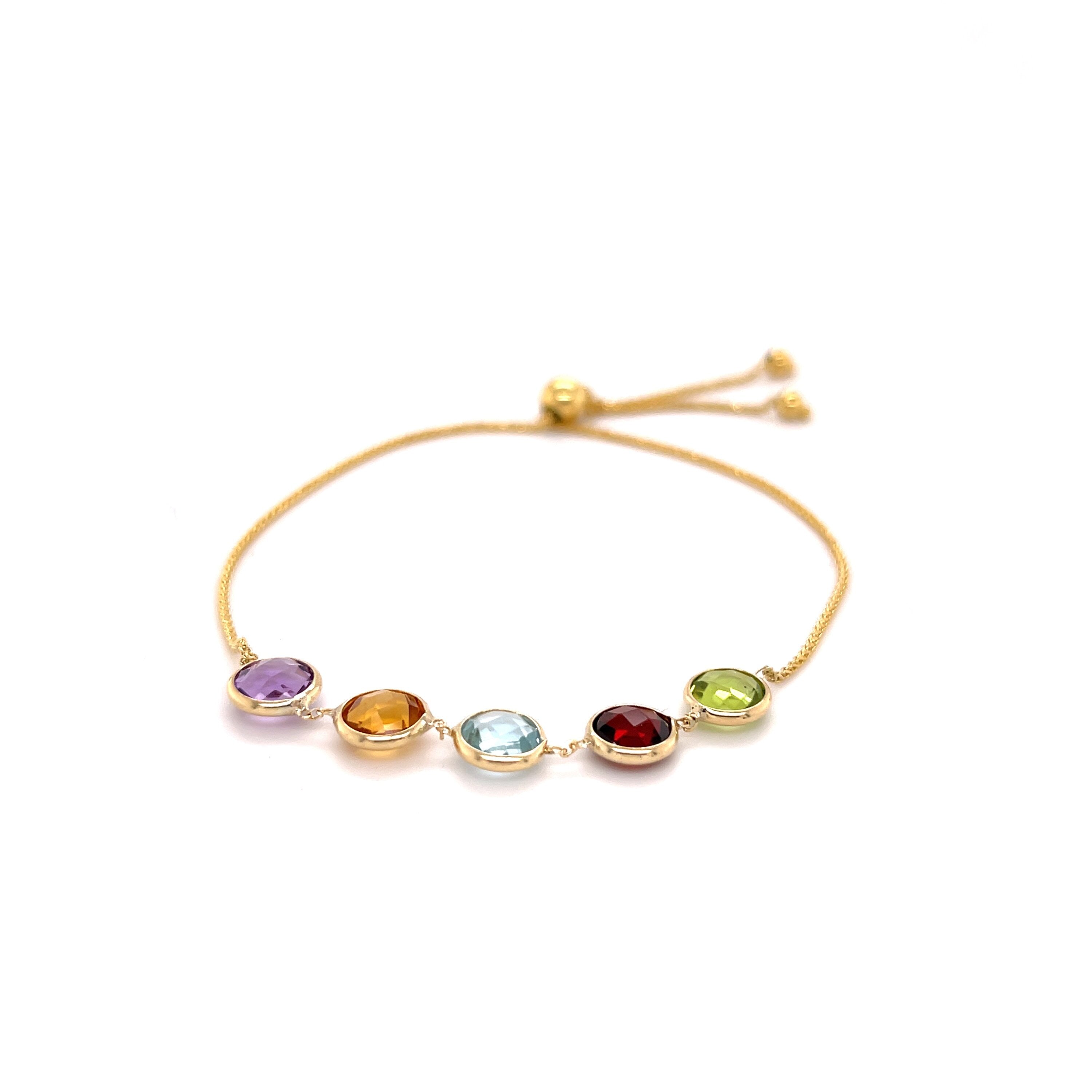 14K yellow gold friendship bracelet featuring natural Peridot, Garnet, Blue Topaz, Citrine, and Amethyst gemstones set in 6 mm round bezels. Designed with a dainty 1 mm chain and an adjustable slide clasp for comfort and durability, this versatile fine jewelry piece is perfect as a birthstone gift for birthdays, anniversaries, weddings, or milestone celebrations.