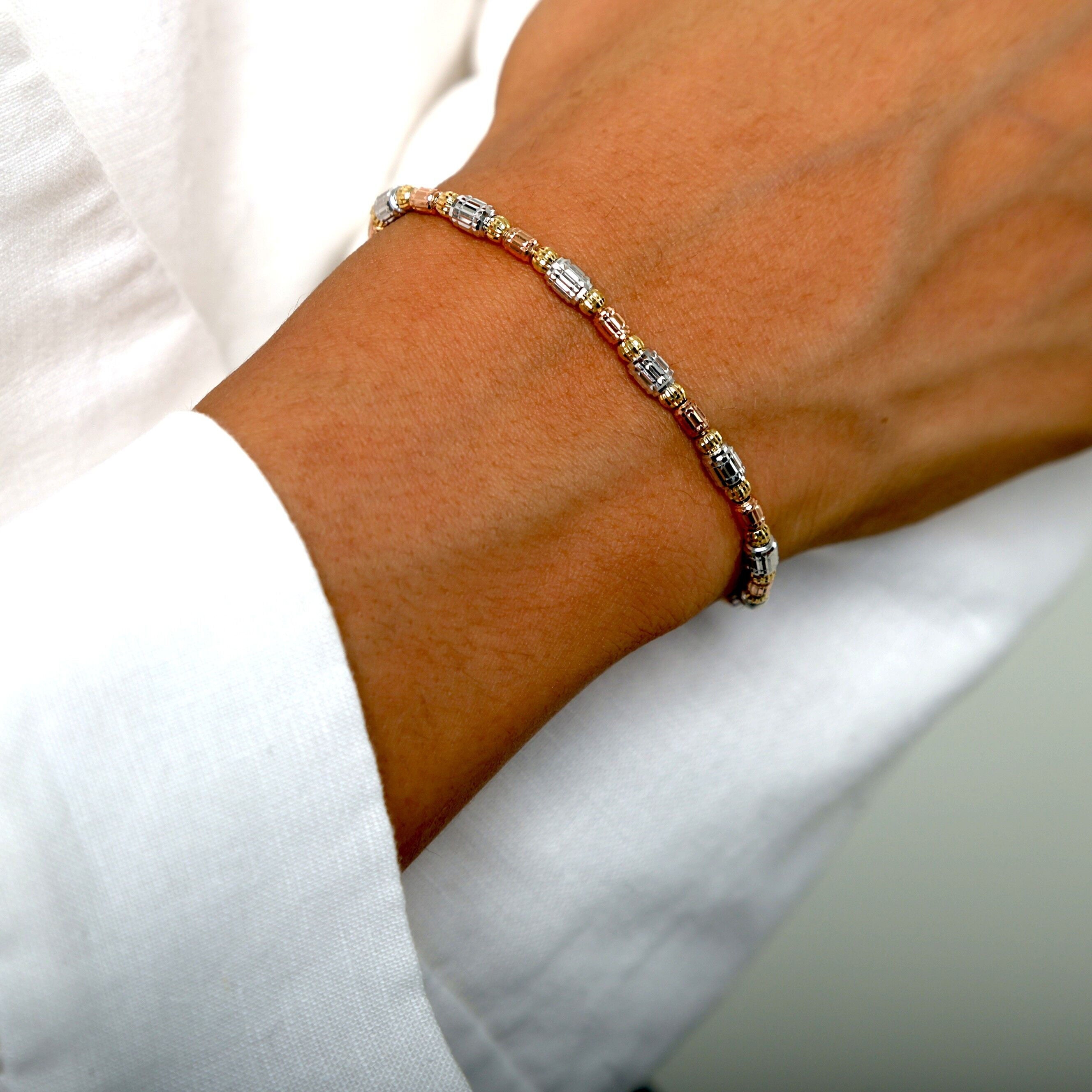 14K Tricolor Gold Barrel Bead Bracelet styled with a crisp white blouse, perfect for adding subtle sparkle and elegance to a daytime look.