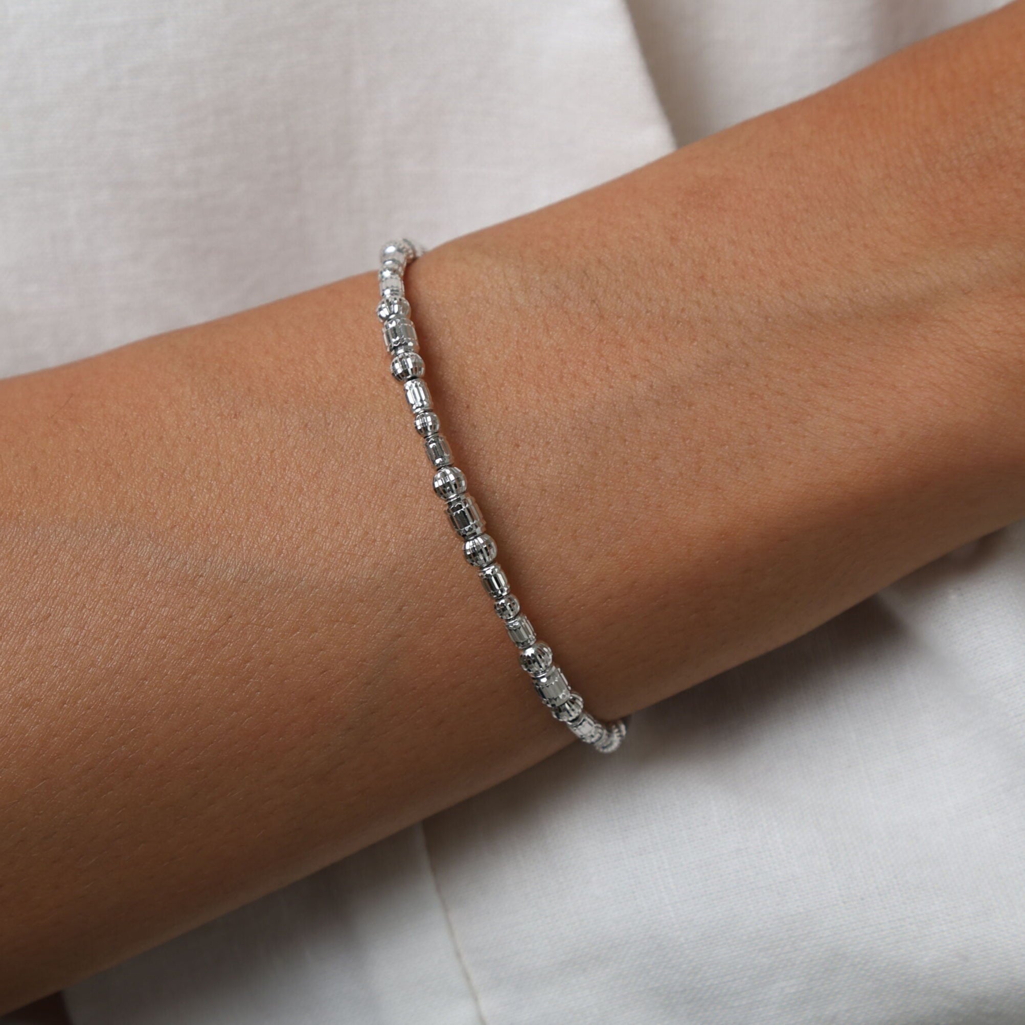 14K White Gold Barrel Bead Bracelet paired with a classic white shirt, creating a clean and polished look ideal for daytime occasions.