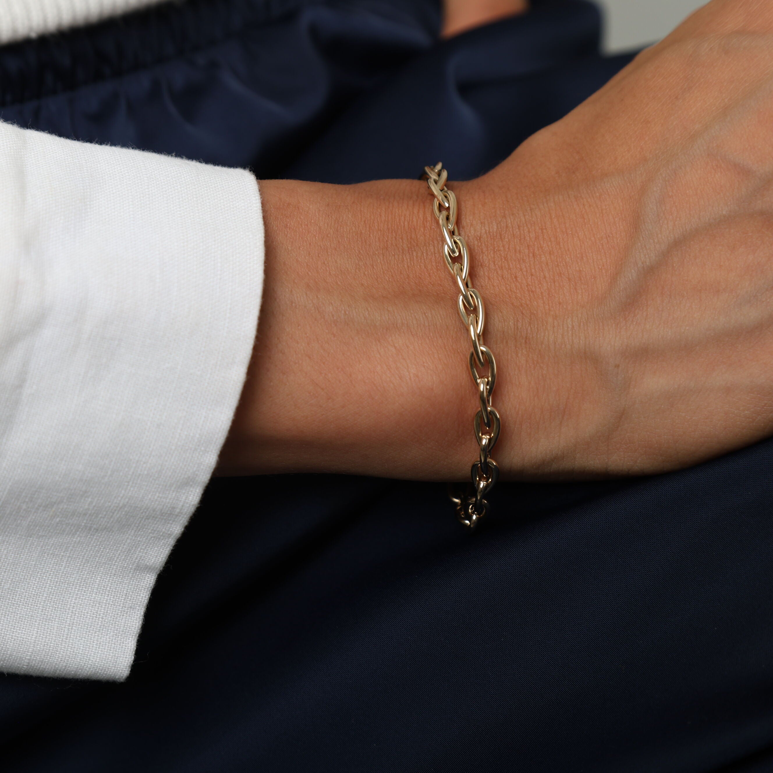 14K Yellow Gold Pear-Shaped Link Bracelet styled with navy blue pants and a white blouse, perfect for polished, professional looks.