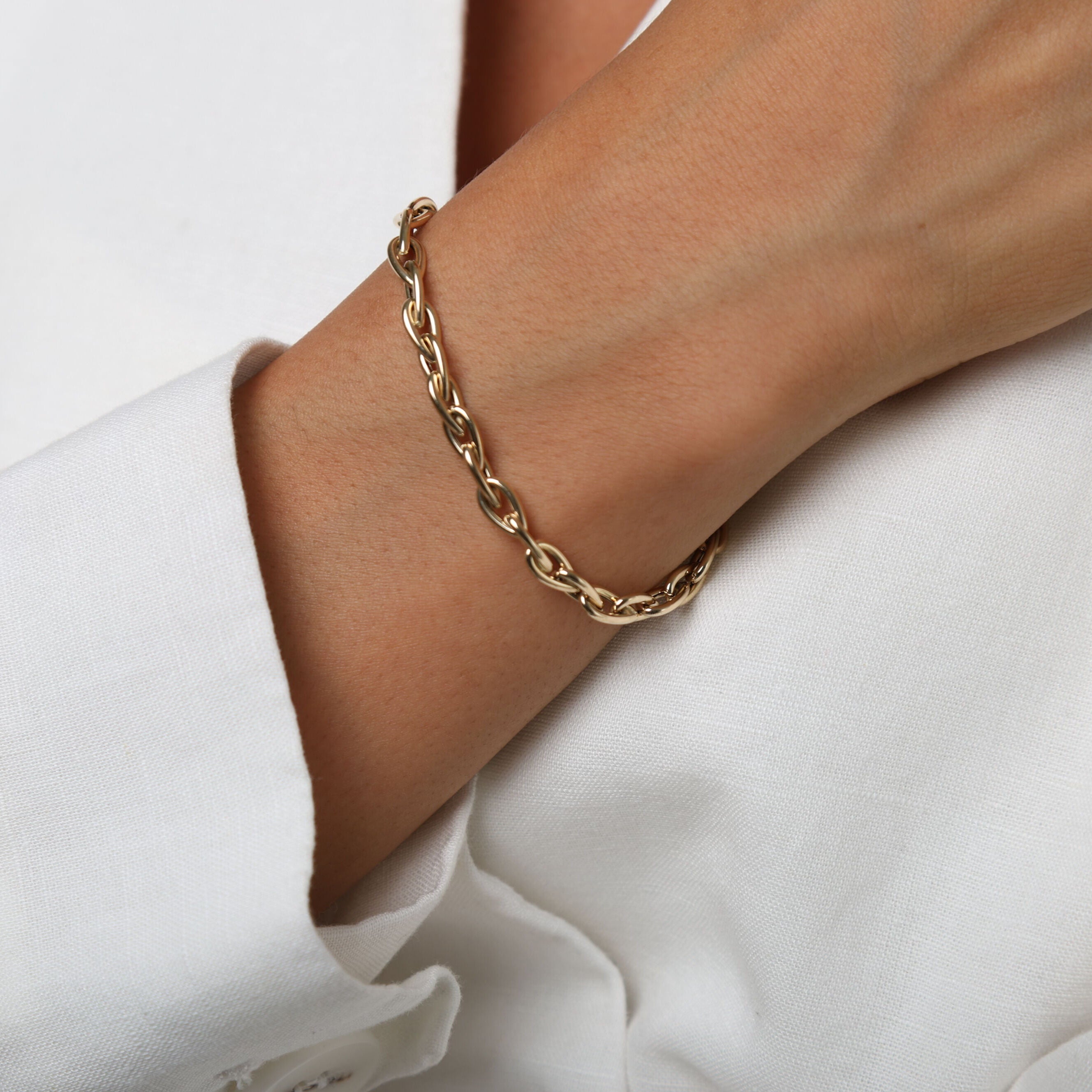 14K Yellow Gold Pear-Shaped Link Bracelet paired with a crisp white shirt, offering timeless elegance for both casual and formal settings.