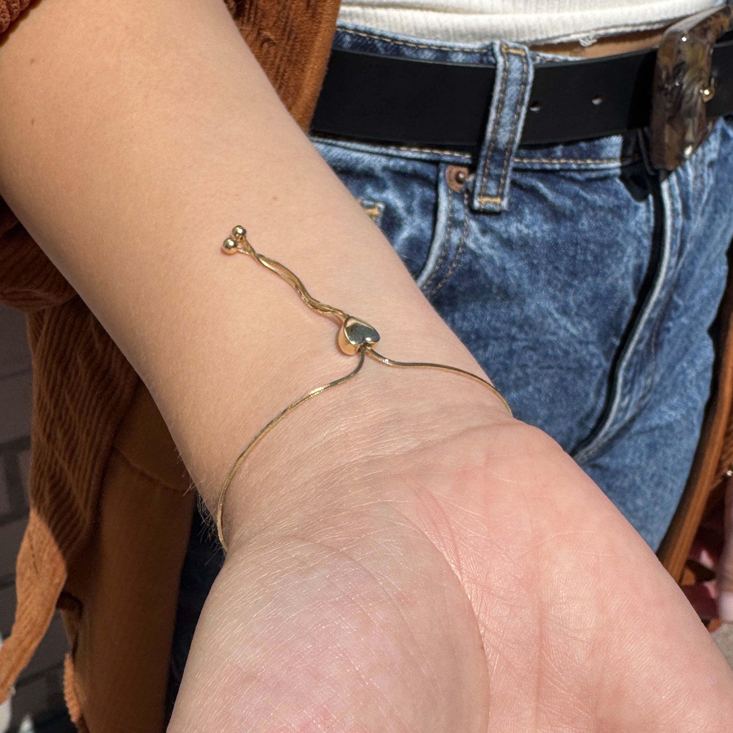 14K Gold Heart Slide Friendship Bracelet styled with earth-tone corduroy, white tank, and gold ring, perfect for fall layers or casual brunch settings