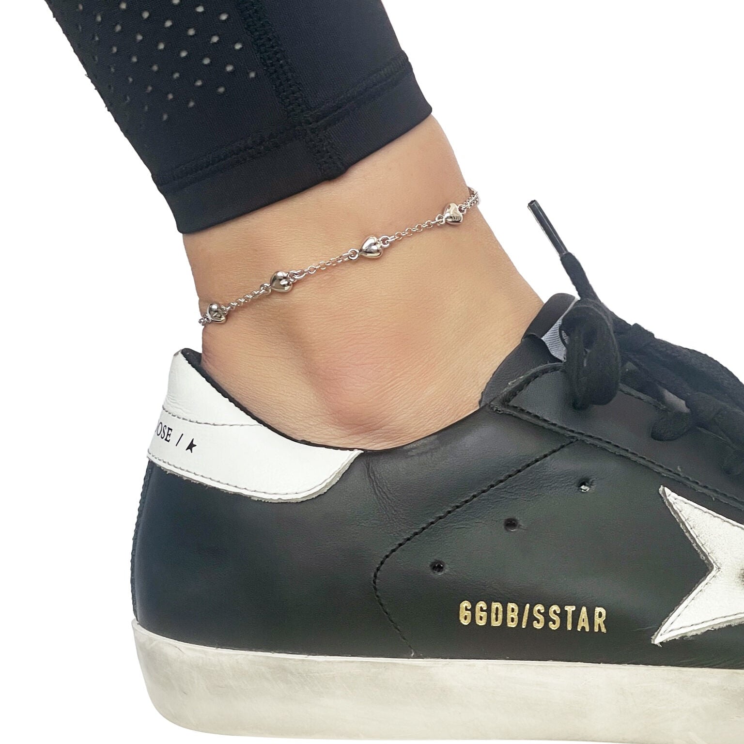 14k white gold puffed heart station anklet on a model's ankle