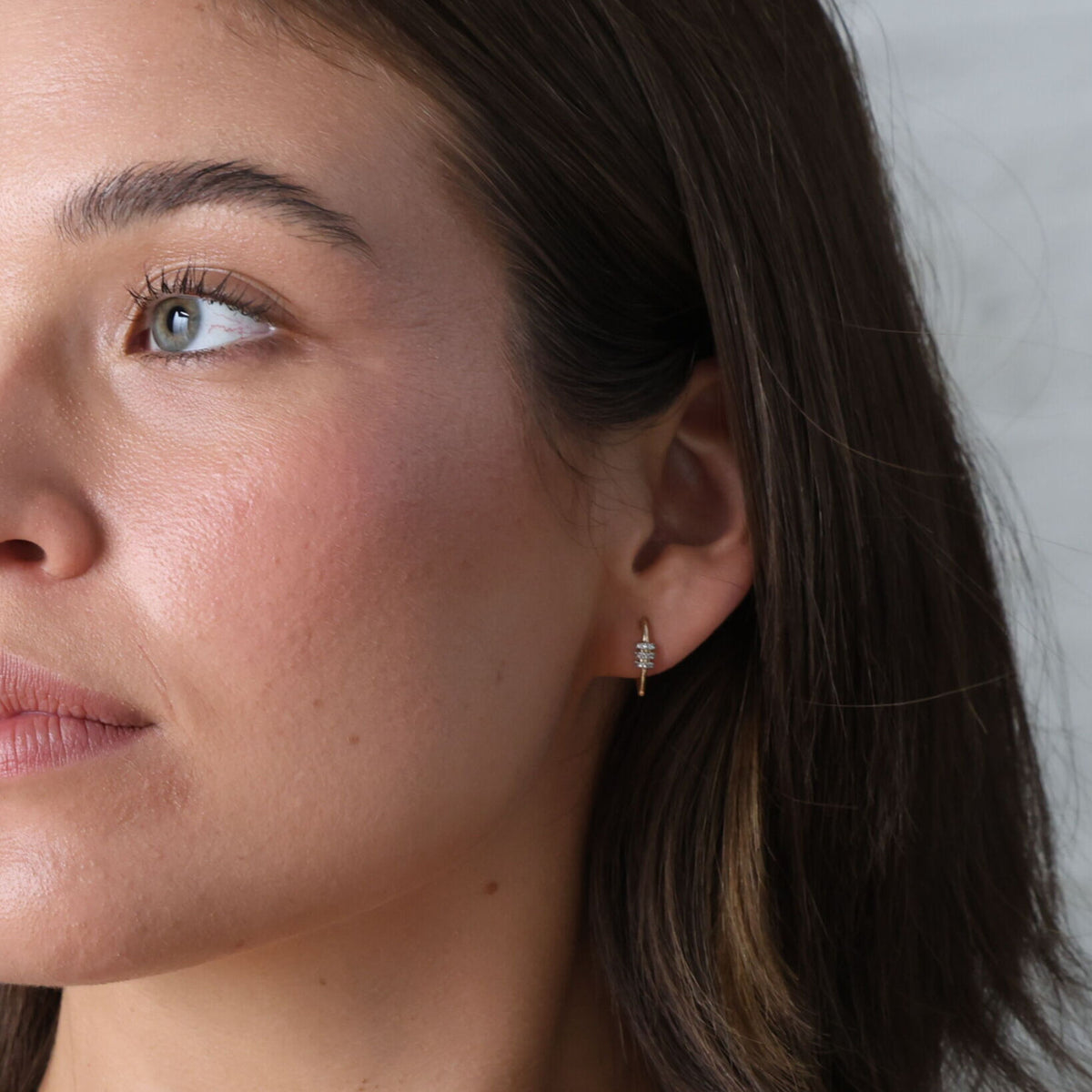 model wearing 14K Gold Heart Carabiner Diamond Huggie Hoop Earrings