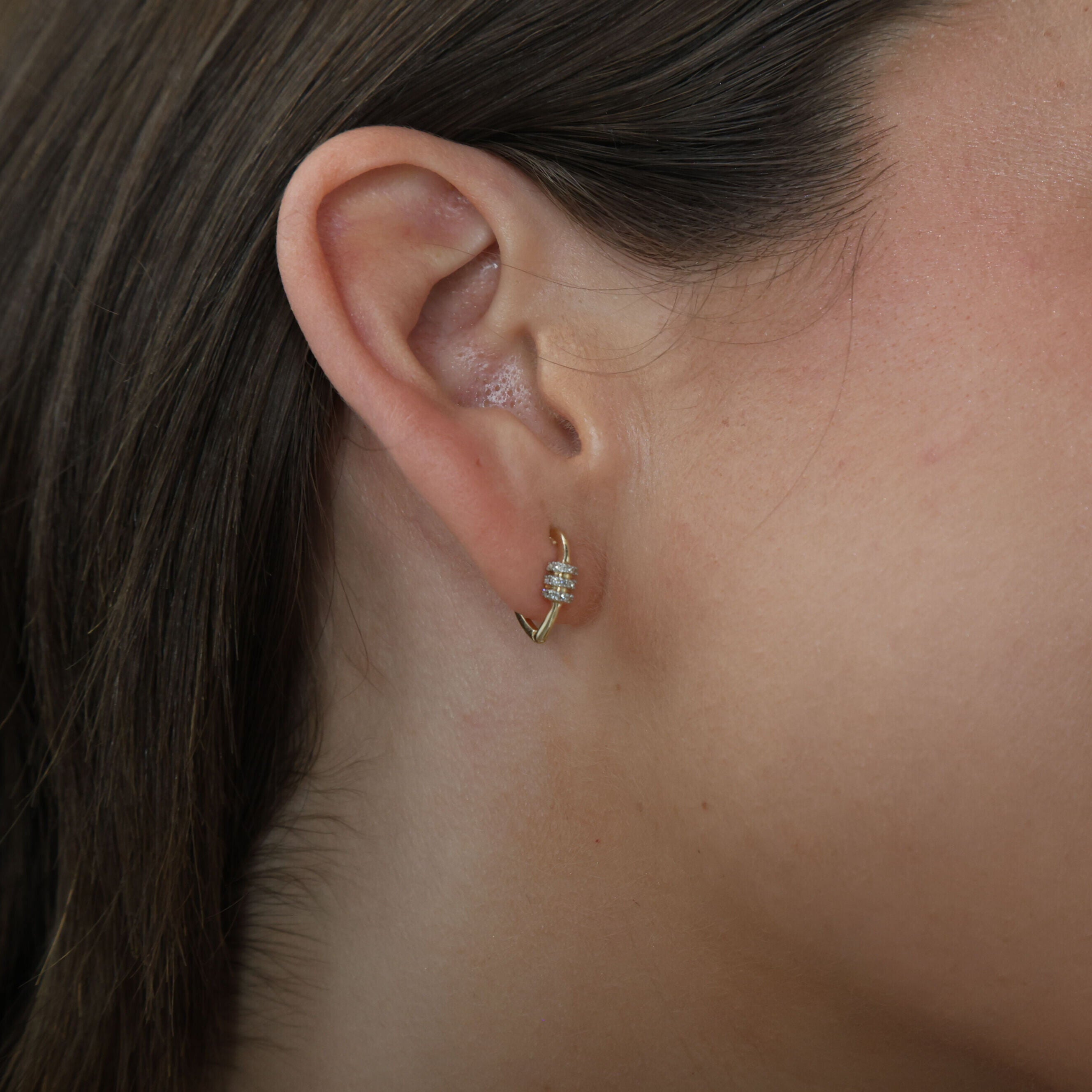 model wearing 14K Gold Heart Carabiner Diamond Huggie Hoop Earrings