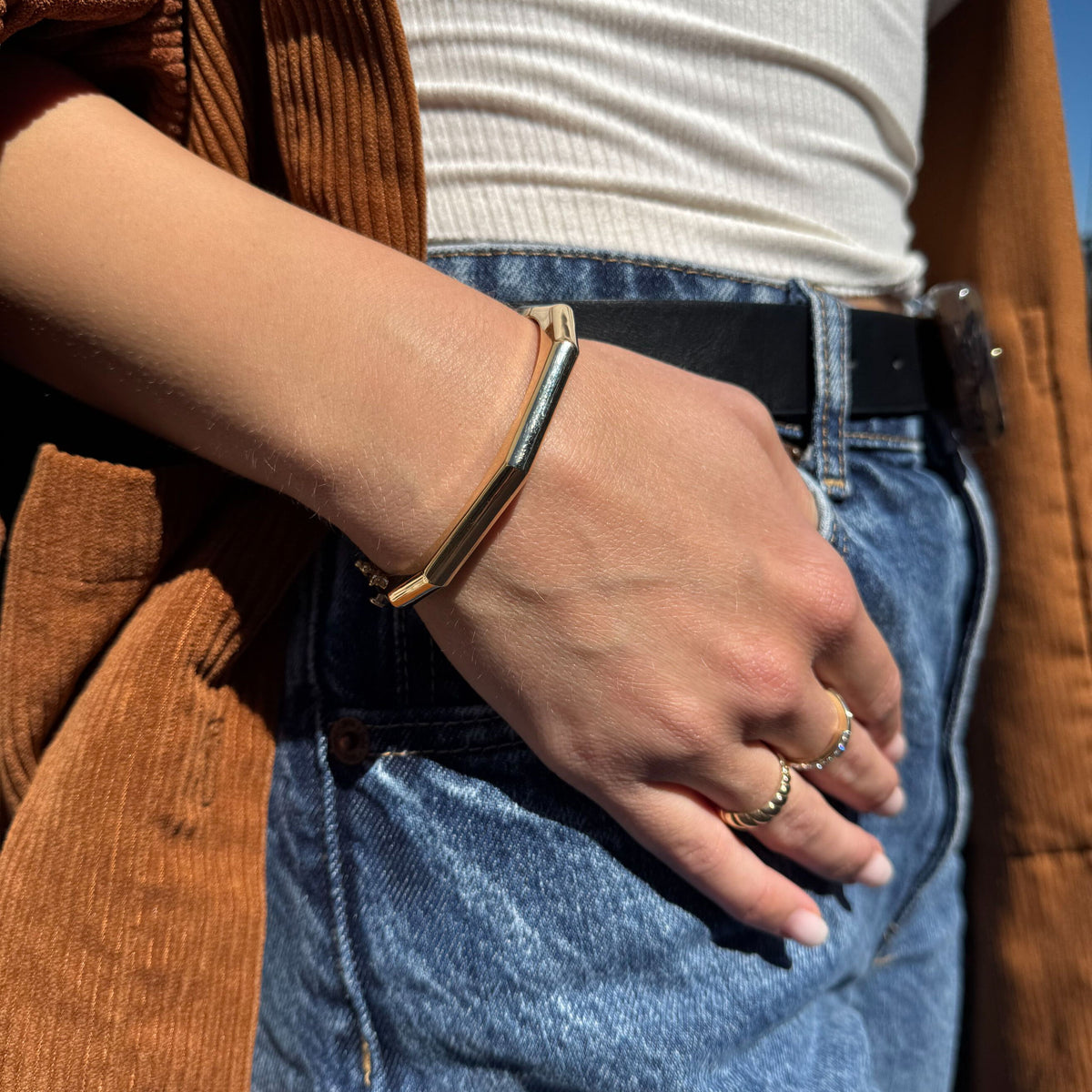 Close-up of 14K yellow gold octagonal hinged bangle showing high-polish finish and eight angled sides