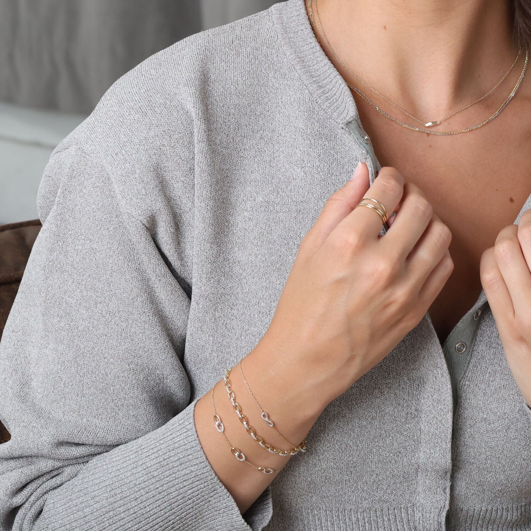 Diamond Oval Link Chain Bracelet in 14K Yellow Gold paired with simple rings and a casual grey sweater. Its luminous diamond links bring elegance and calmness to the outfit, making it suitable for daily wear, casual lunches, or thoughtful anniversary gifts.