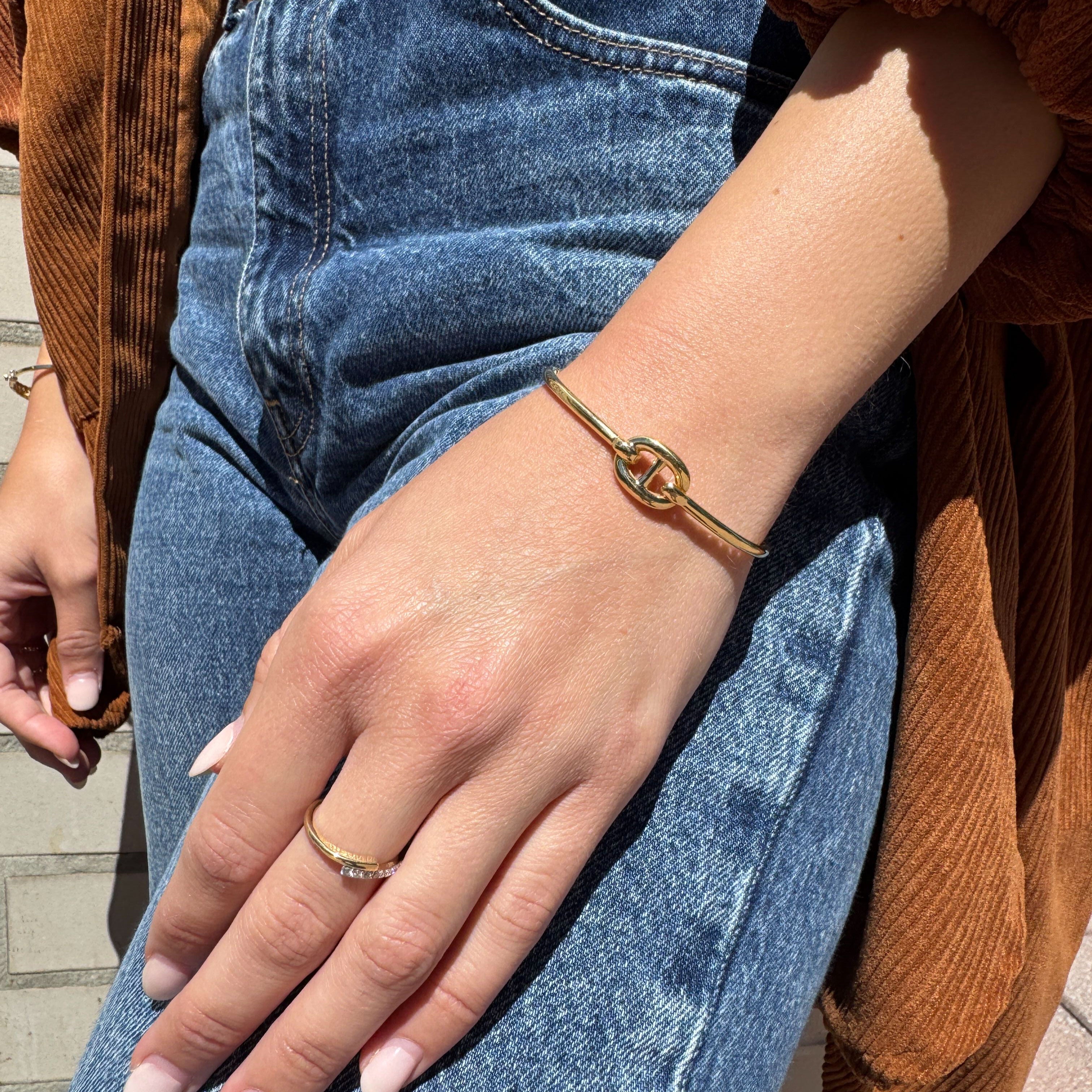 Minimalist 14K gold mariner link bangle bracelet styled with denim jeans and a brown jacket, elevating a relaxed casual outfit with elegance and confidence. A versatile accessory for workdays, coffee meetups, and everyday wear.