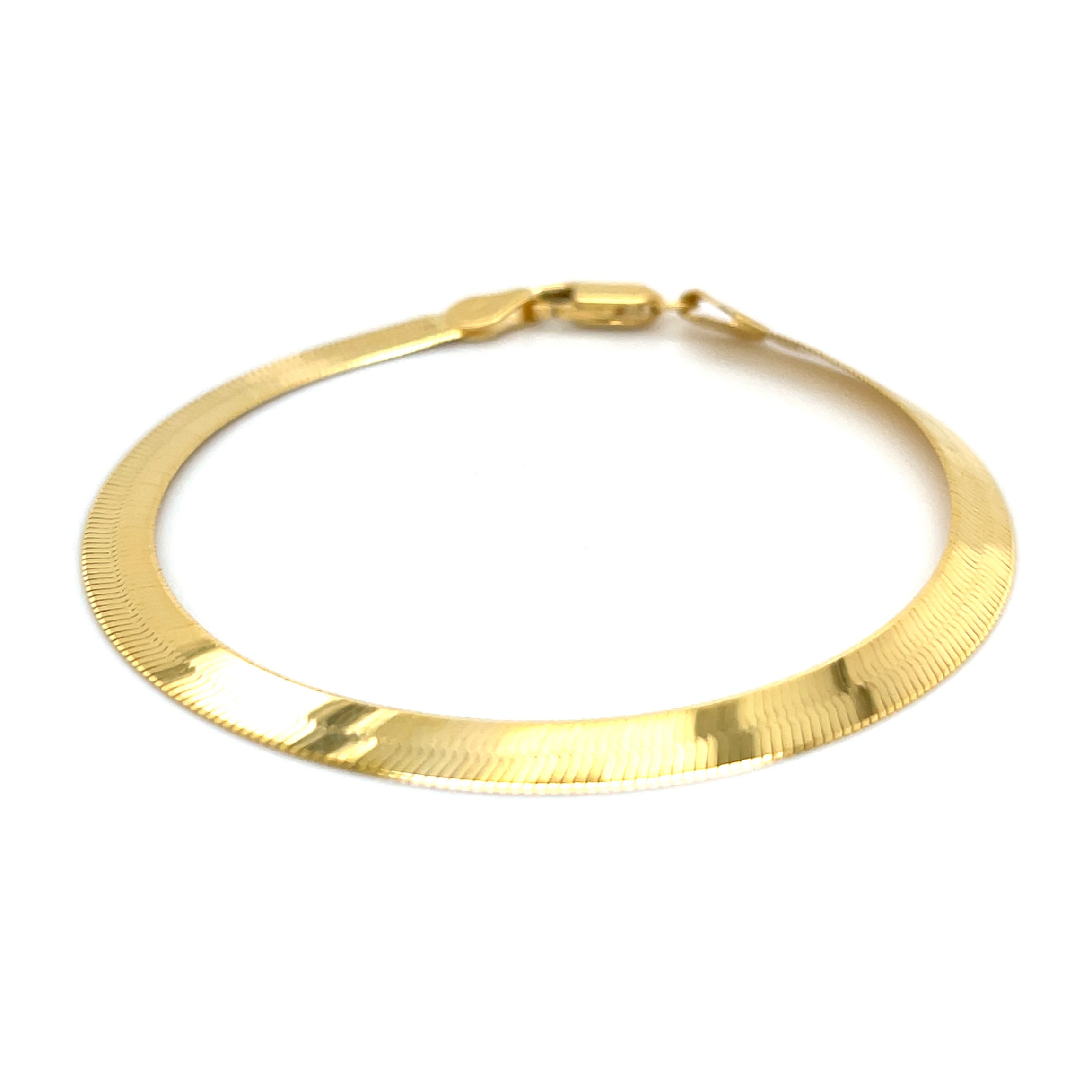 14K yellow gold herringbone bracelet with a sleek, luminous finish and flat chevron links that rest smoothly on the wrist. Elegant and comfortable for everyday wear, this bracelet is durable, tarnish-resistant, and secured with a sturdy lobster claw clasp. A timeless fine jewelry gift for birthdays, anniversaries, weddings, or milestone celebrations.