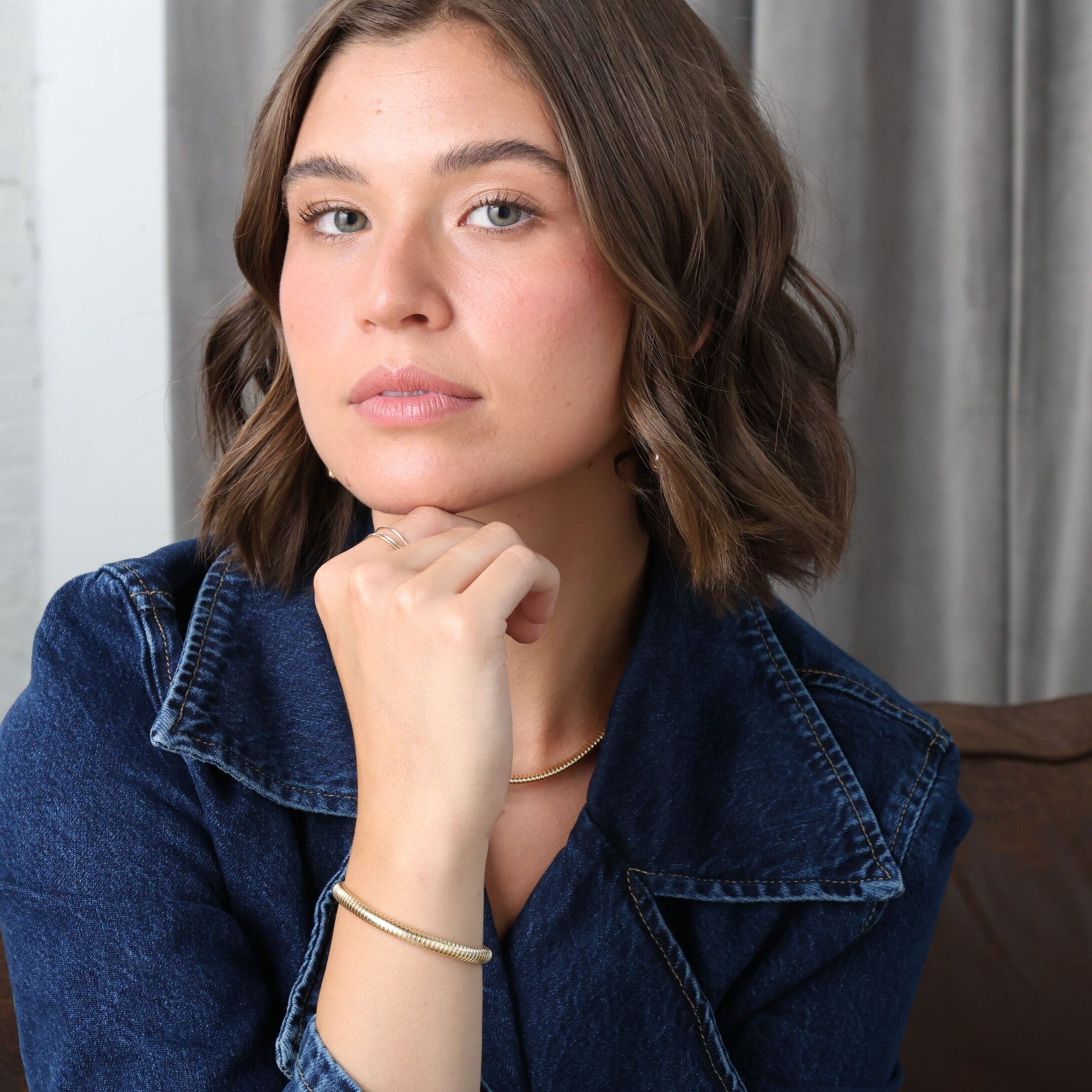 Classic solid gold Tubogas bracelet worn on the wrist with a simple neutral-toned outfit, highlighting timeless elegance and versatility. Perfect for everyday style, anniversaries, and milestone events.