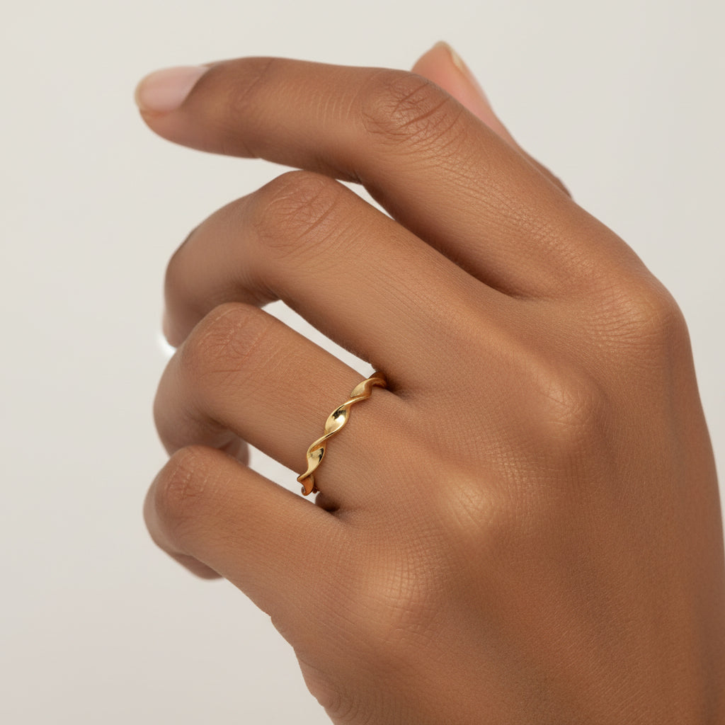 14K yellow gold twisted band ring styled on hand for an elegant everyday look