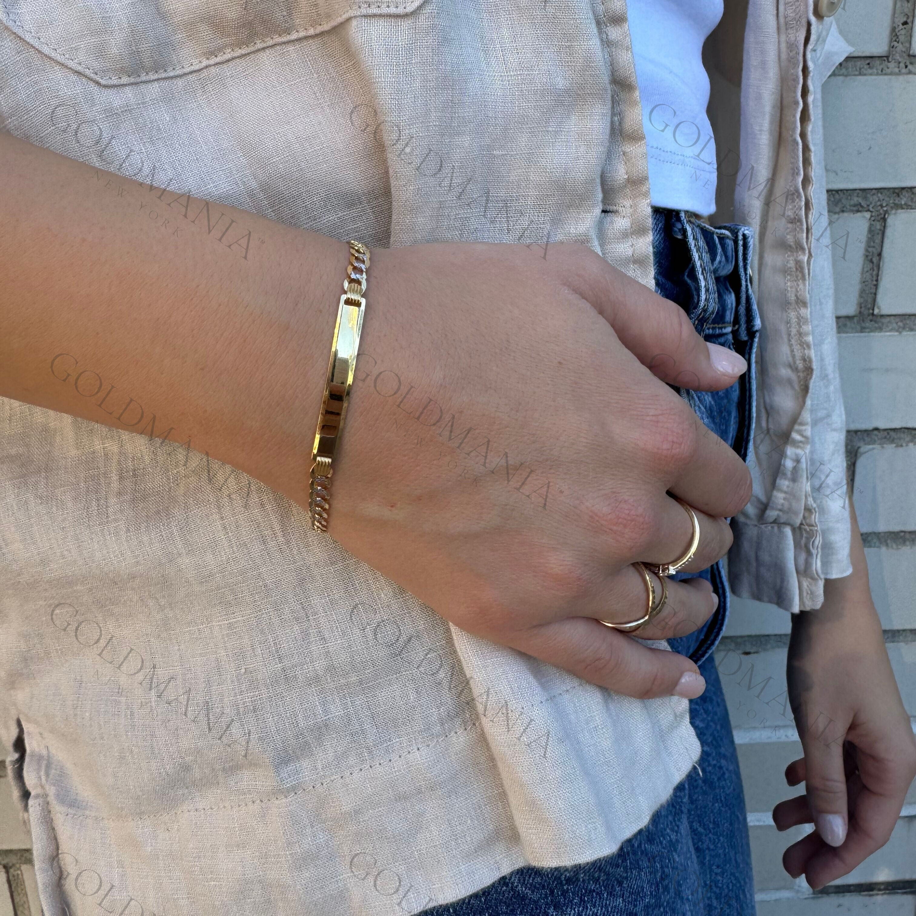 14K Two Tone Gold ID Bracelet layered with delicate rings and a neutral blouse, adding sophistication to a minimalist style. A durable and elegant jewelry piece suited for birthdays, weddings, and meaningful occasions.