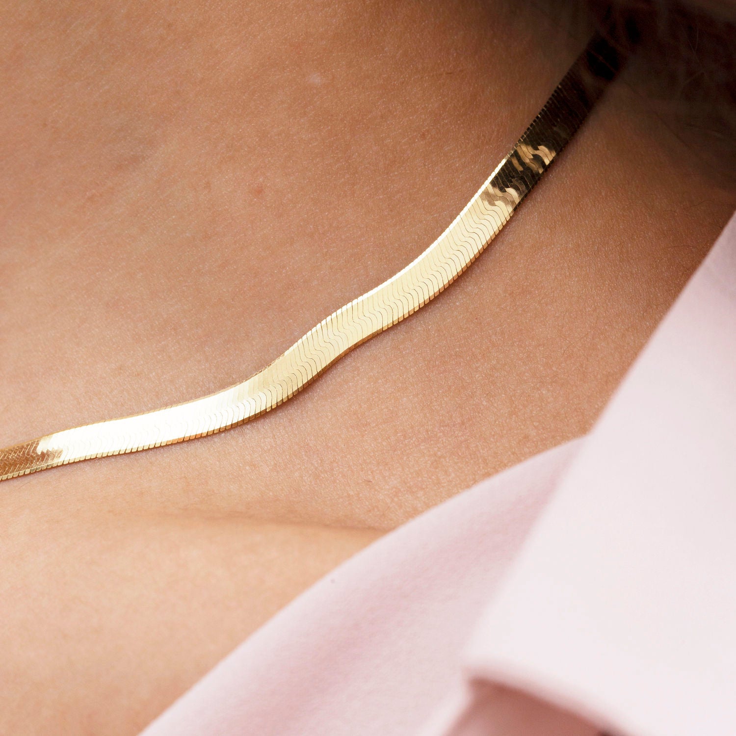 14K Solid Yellow Gold Herringbone Necklace styled with a soft V-neckline, sitting smoothly along the collarbone for a confident and elegant everyday look. The flat polished chain adds timeless sophistication, perfect for workdays, casual meetings, or effortless daytime wear.