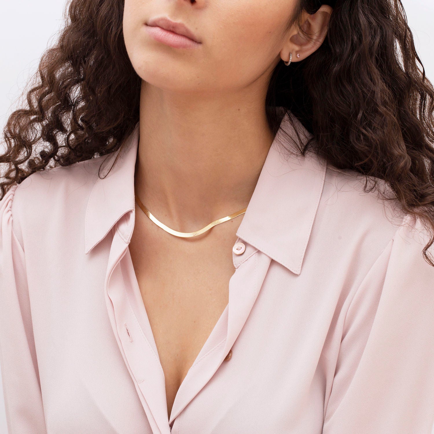 14K Solid Yellow Gold Herringbone Necklace worn with a tailored blazer and open neckline for a polished, modern look. The sleek flat chain brings effortless elegance and clarity, perfect for dinner plans, social events, or transitioning from day to night style.