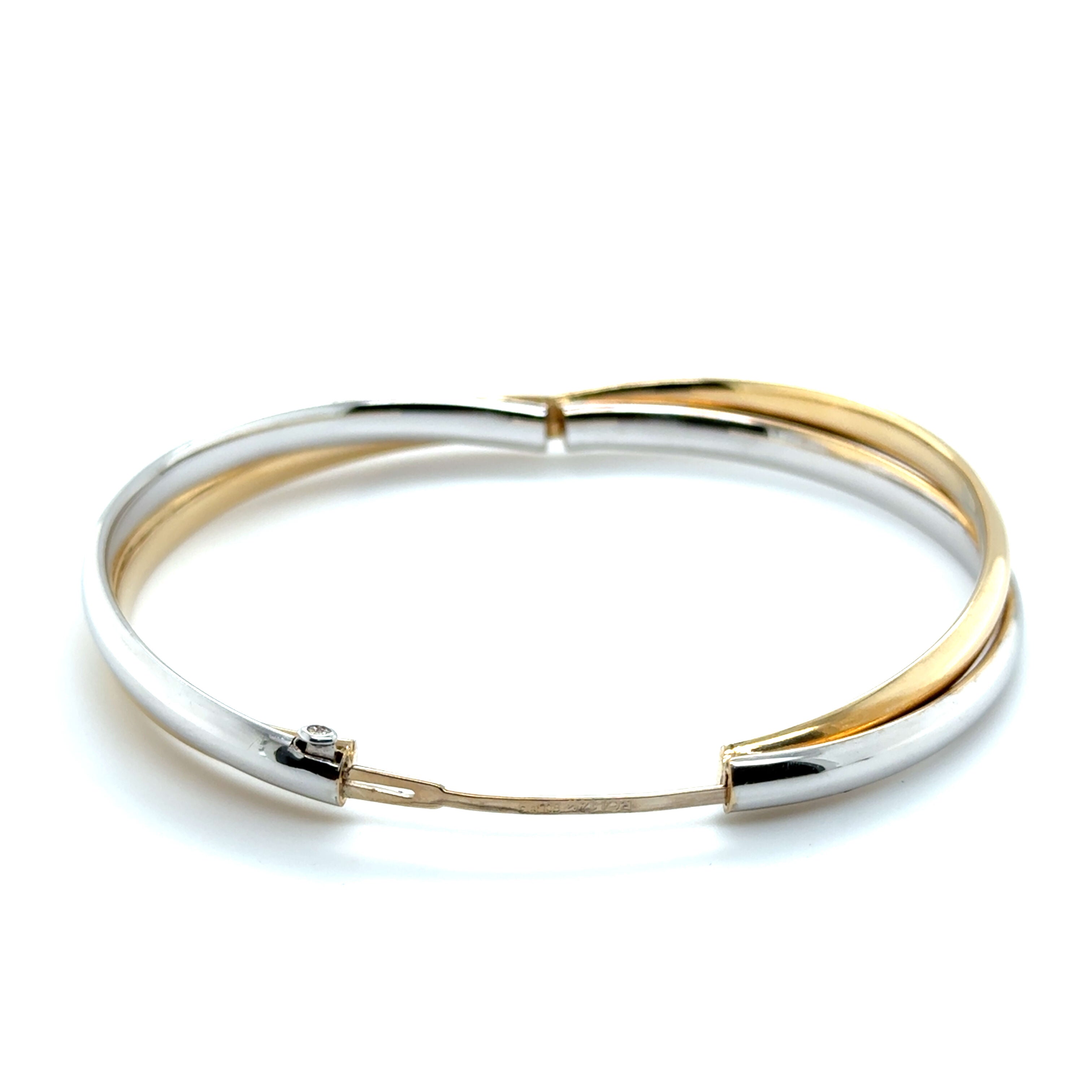 Interlocking yellow and white gold bands create a polished, timeless bangle, promoting poise and elegance. A luxurious gift for graduations or anniversaries.