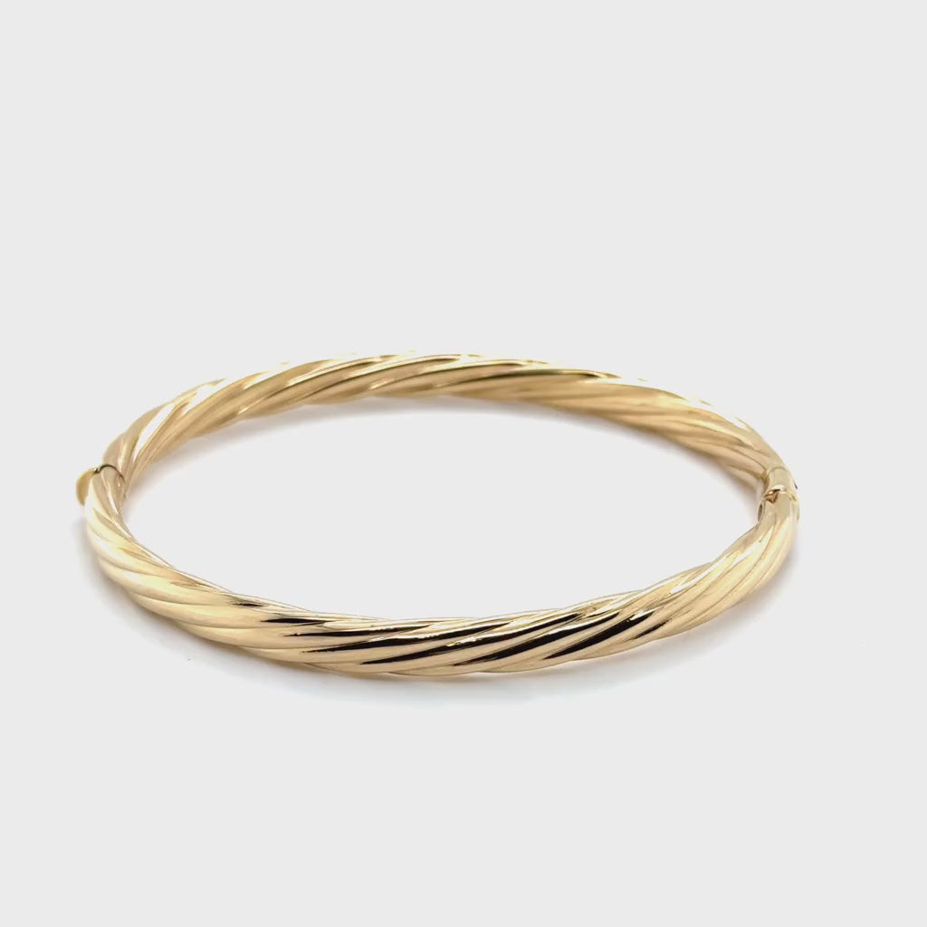 Rotating video preview of the 14K gold 5mm bangle bracelet highlighting its twist design and 7.5-inch hinged clasp.