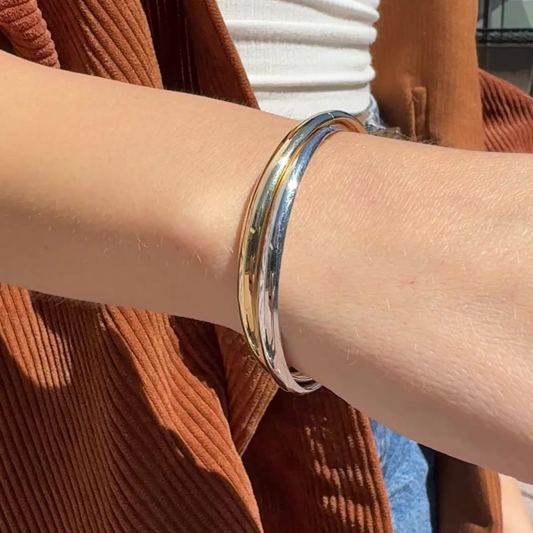 Styled with a bold chain necklace, the 14K Crossover Bangle offers a clean contrast, perfect for layering with casual or professional looks.