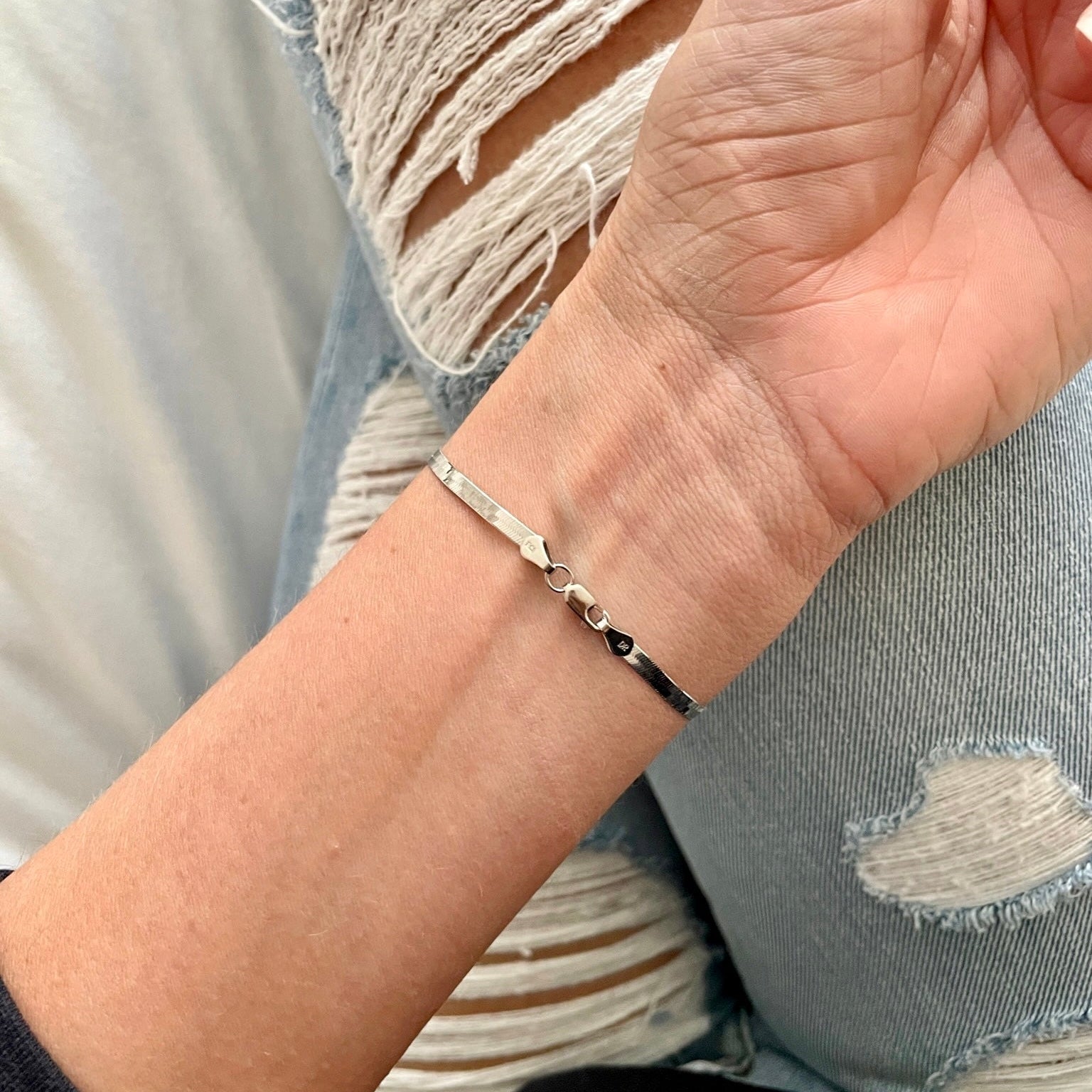 14K White Gold Herringbone Bracelet worn with distressed denim for effortless chic style, complementing day-to-night outfits.