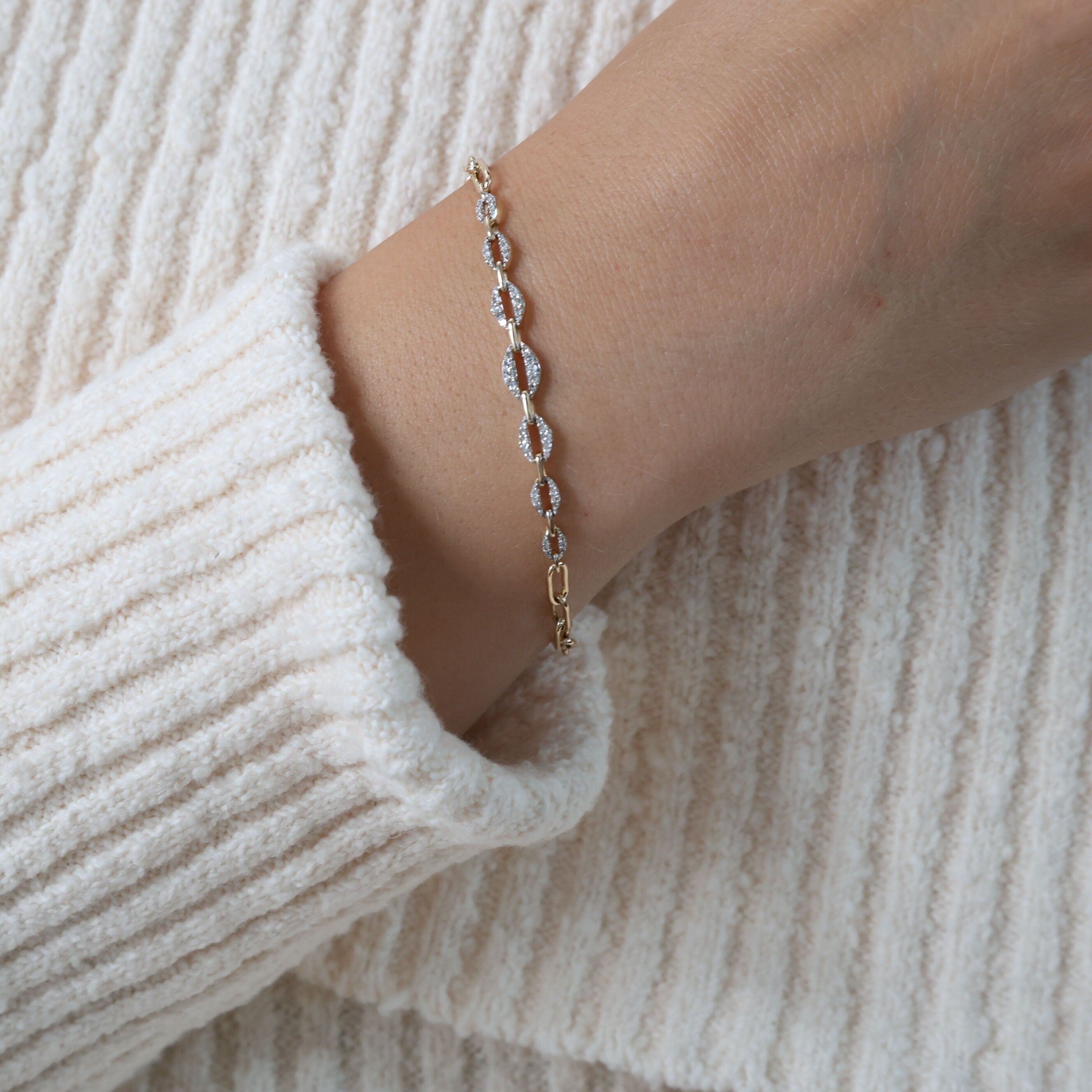 The 14K Gold Diamond Graduated Link Bracelet beautifully complements a cozy white sweater and casual look, adding a touch of elegance to everyday style. Its versatile design enhances your wrist, making it perfect for workdays or casual meetings.