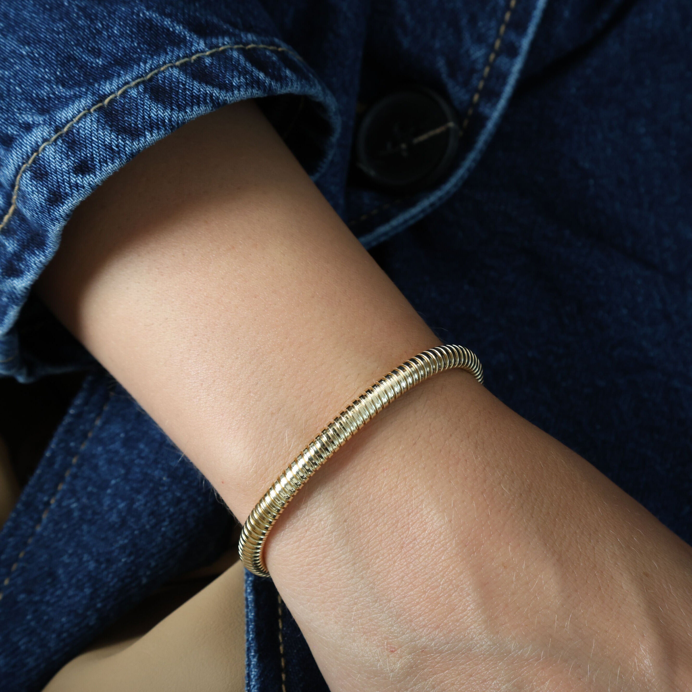 14K yellow gold Tubogas bracelet styled with a casual denim jacket, adding a touch of elegance and confidence to an everyday outfit. Ideal for workdays, casual meetings, or weekend outings.