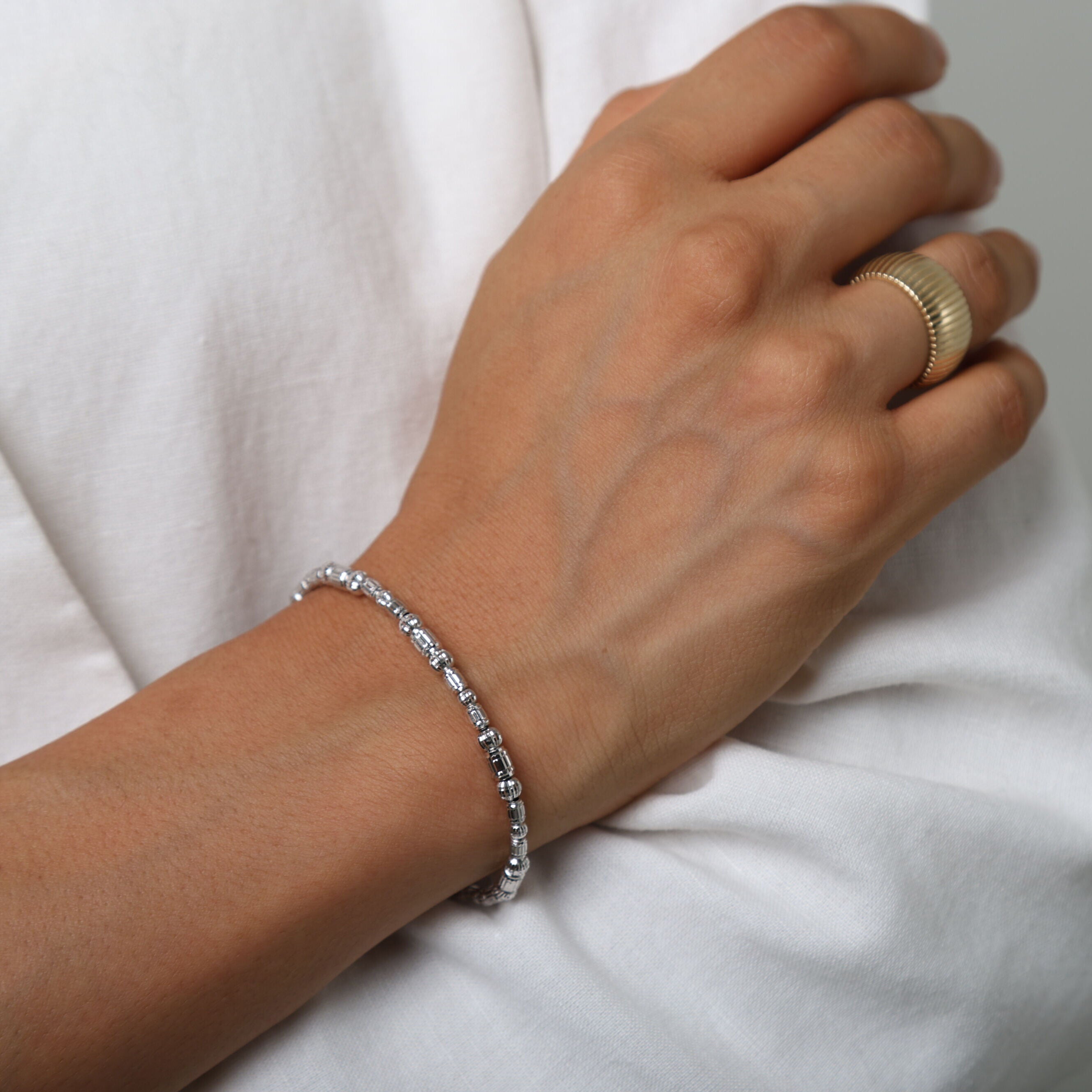 14K White Gold Barrel Bead Bracelet worn with a casual white sweater, offering a cozy yet refined style perfect for relaxed settings.