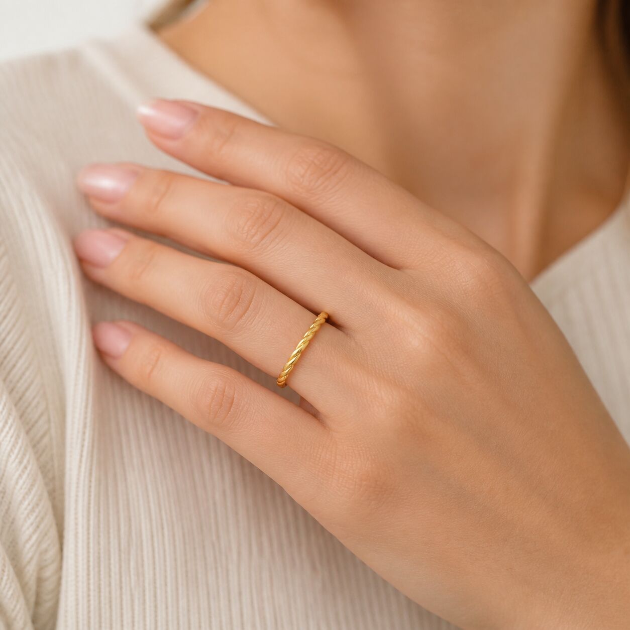 14K yellow gold rope band ring styled on hand with polished twisted gold detailing