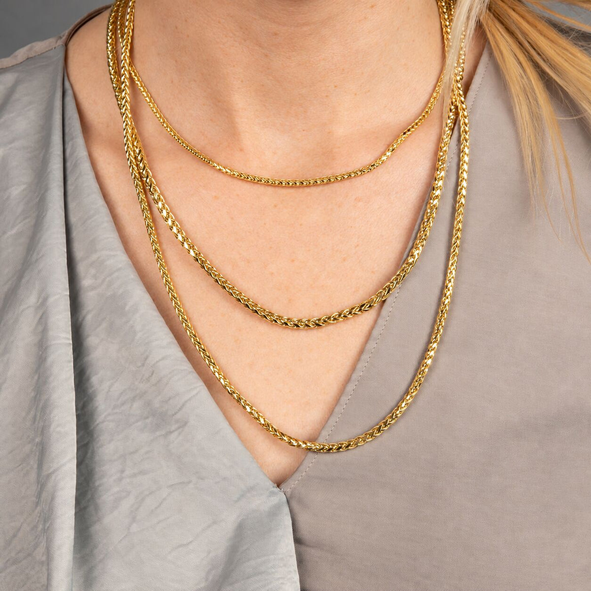 Close-up of lobster clasp on 14K yellow gold diamond-cut round wheat chain necklace