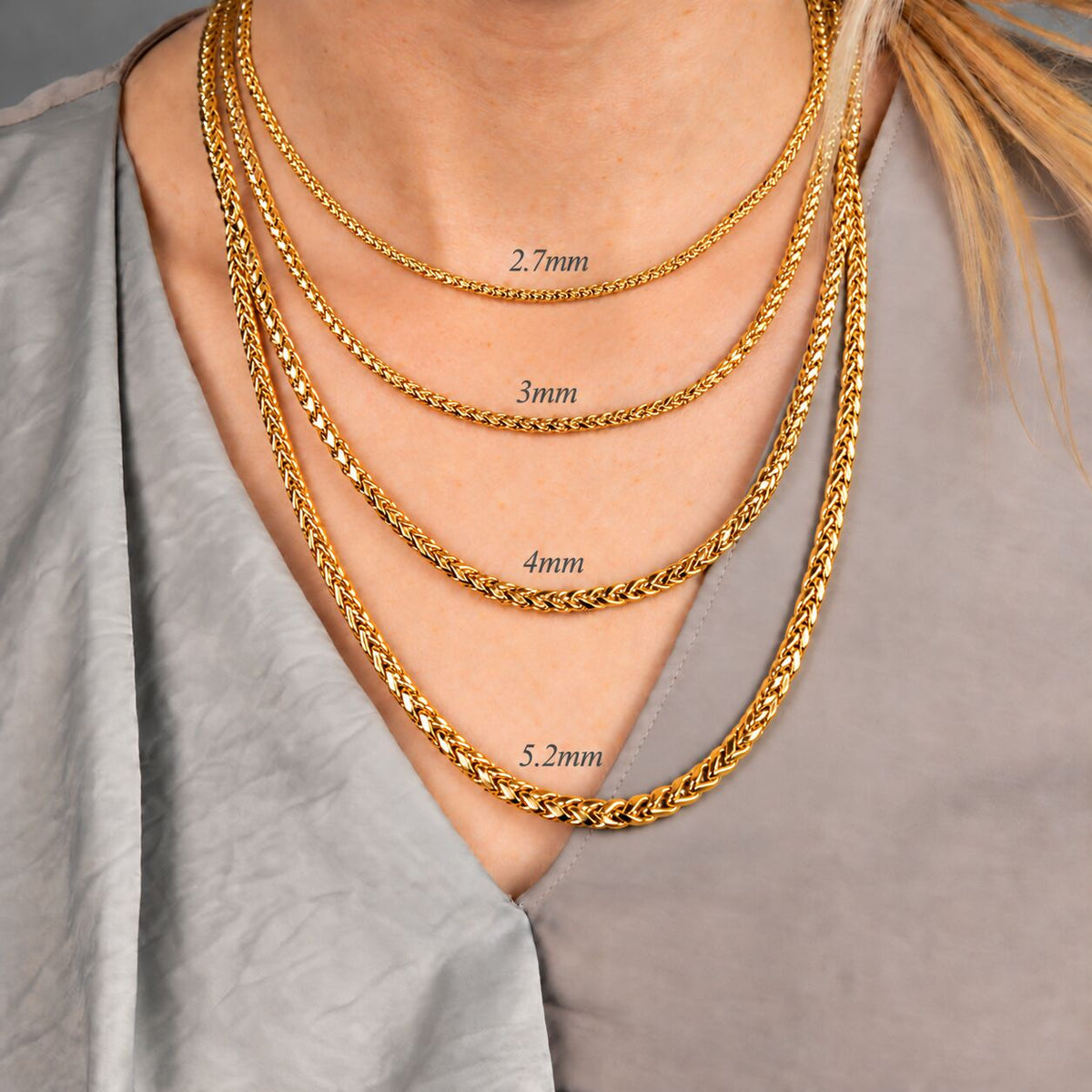 Spiral of 14K yellow gold round wheat chain with diamond-cut facets glinting on black velvet