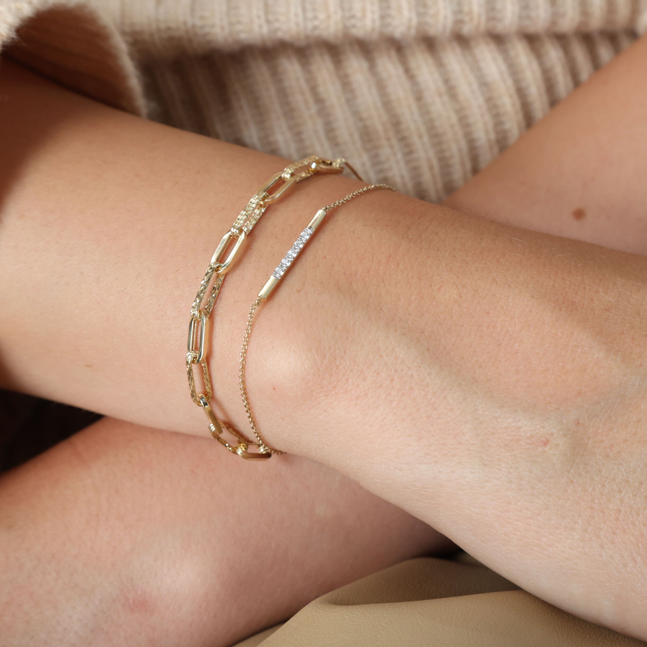 Diamond Bar Chain Bracelet in 14K Yellow Gold styled on the wrist with a chunky link bracelet and cozy knitwear. The dainty diamonds add subtle sparkle that enhances confidence and elegance, making it perfect for workdays, casual meetings, or everyday style.