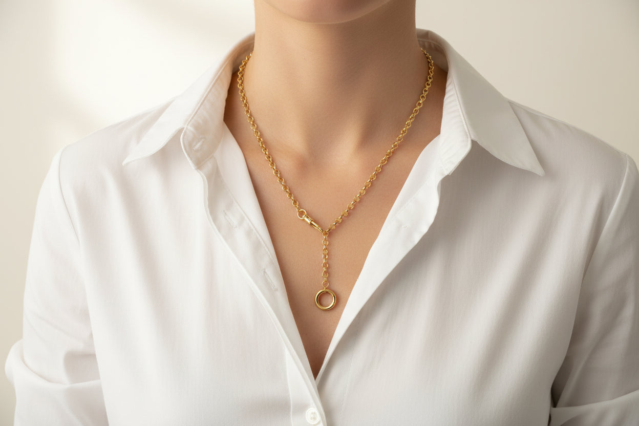 Gold necklace with a small round pendant on a white background