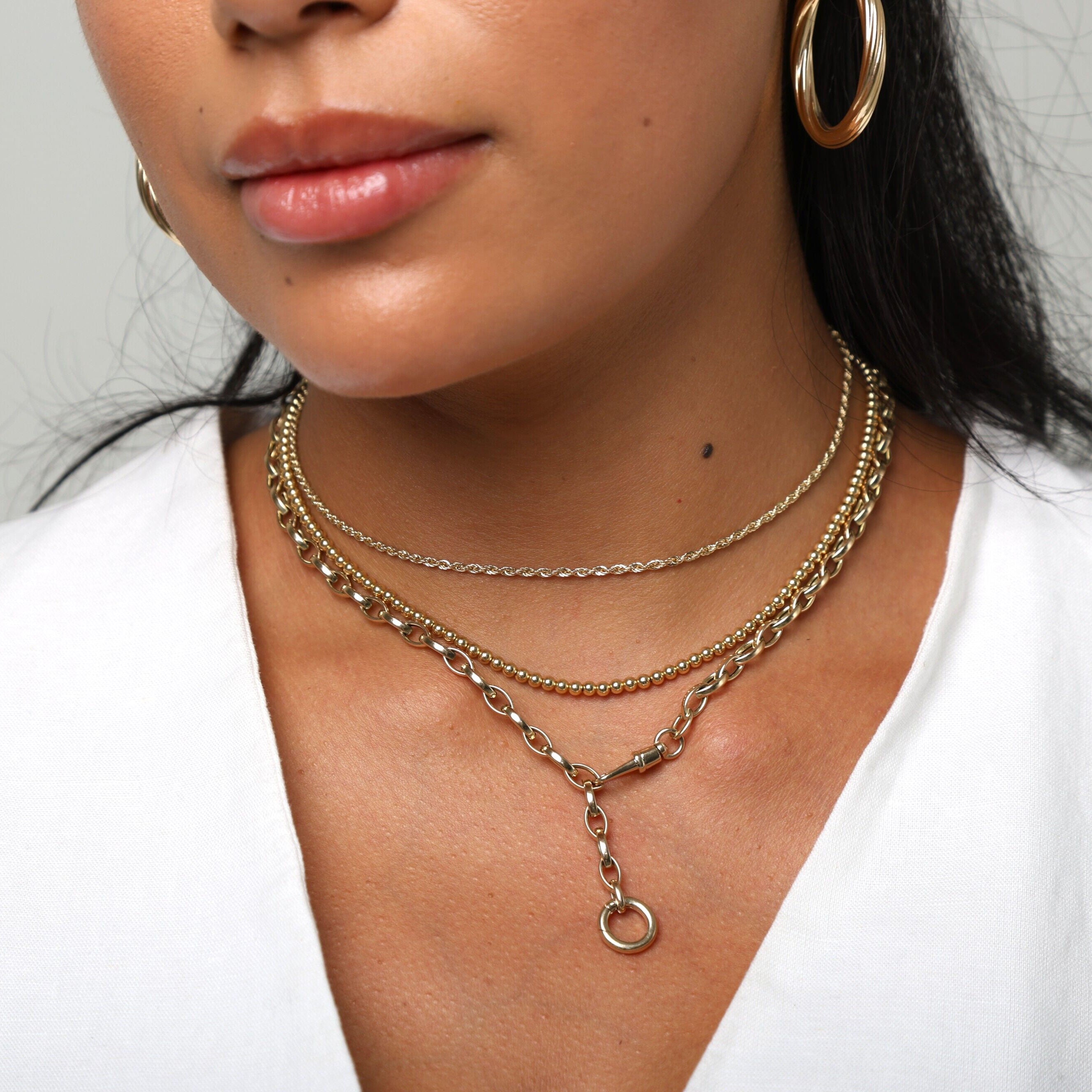 14K Yellow Gold Double Clasp Lariat Necklace worn with a deep V neckline top, adding warmth, clarity, and modern femininity for elevated daytime wear, brunch outings, and effortless everyday style.
