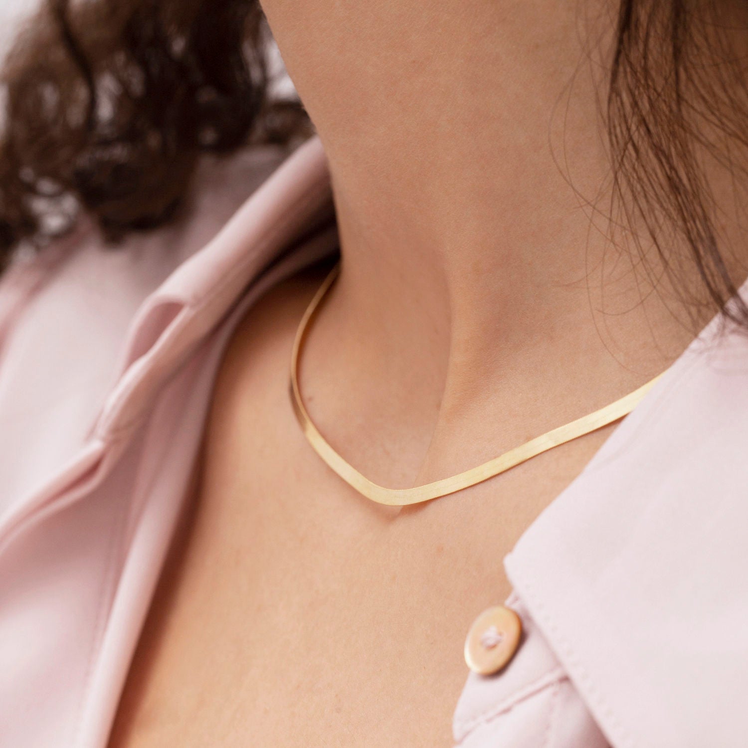 14K Solid Yellow Gold Herringbone Necklace styled with a soft V-neckline, sitting smoothly along the collarbone for a confident and elegant everyday look. The flat polished chain adds timeless sophistication, perfect for workdays, casual meetings, or effortless daytime wear.